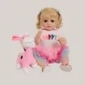 55cm reborn baby doll with blonde curls and pink tutu next to a plush giraffe toy - Realistic Girl Doll With Giraffe (2189) / Full Silicone Body / Pale Blue