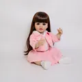 55cm lifelike reborn baby doll Betty with brown hair and pink outfit in sitting pose - Full Silicone Realistic Version / Pink and White / 55 cm