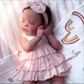 Sleeping 19-inch reborn baby girl doll in pink ruffled dress and lace headband - Cloth Body Style / Pink