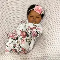Lifelike 19-inch reborn baby doll in floral wrap with flower headband on knit blanket - Full Silicone Body Style