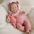 Close-up of sleeping reborn baby doll in pink knit overalls with matching teddy bear - Pink Knitted Outfit (2157) / 50cm Cloth Body