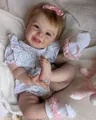 Reborn pop in bloemenpakje met roze satijnen strik en een delicaat gouden armbandje - Grote Maat / Bloemen Romper Stijl (3004)