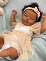 Reborn doll with African features wearing a white bodice and pink ribbon headband - Dark Skin Mesh Skirt Style