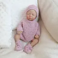 Realistische 10-Zoll Baby-Puppe in rosa handgestricktem Outfit und Mütze auf weicher Decke - Stoffkörperpuppe (NPK-3011) / Rosa