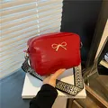 Chic red square shoulder bag with golden bow hardware and woven geometric strap - Red