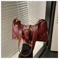 Dettaglio di borsa tote in ecopelle rosso scuro lucido con finiture in metallo oro - Rosso