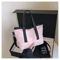 Sac fourre-tout rose minimaliste avec bandoulière noire sur fond de boîte cadeau - Rose