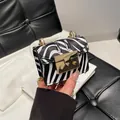 Mini crossbody bag featuring a bold black and white zebra pattern with a gold chain strap - Zebra Print