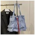 Detailansicht der gestuften Gingham-Tasche mit markantem rotem Kordelzug-Akzent - Blau
