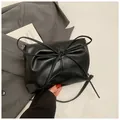 Detailopname van zwarte PU-leren handtas met elegante strik en geplooide textuur afwerking - Zwart