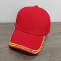 Detail of red cotton baseball cap featuring iridescent rhinestones on the brim edge - Red