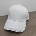 Detail of white cotton baseball cap showing dual rows of iridescent rhinestones on the brim - White