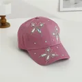 Dettaglio dei tre motivi a farfalla in strass su un berretto da baseball in cotone viola - Magenta scuro