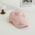 Dettaglio di tre farfalle di strass scintillanti su berretto da baseball rosa chiaro - Rosa