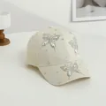 Dettaglio decorazioni farfalla con strass scintillanti su cappellino beige - Beige