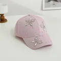 Dettaglio di strass scintillanti a forma di farfalla sul cappellino da baseball rosa - Rosa Loto
