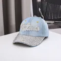 Detailed view of shimmering rhinestones on light blue denim baseball cap with letter pattern - Adjustable / Light Blue