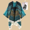 Detail eines Ethno-Strickponchos mit geometrischem Jacquardmuster und weißen Fransen - Ethno-Streifen Seeblau