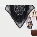 Elegante foulard in seta mandala bianco e nero con motivi bohémien appeso a una gruccia - Grande Loto Nero / 70x70cm