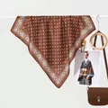 Brown geometric printed silk scarf with bohemian patterns hanging on a display rack - Coffee Grid Border