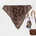 Classic dark brown paisley silk scarf styled with a leather handbag on a rack - Dark Brown