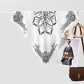 Detailed view of cream silk scarf with black mandala prints hanging on a rod - Lotus