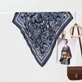 Navy blue silk scarf with white paisley pattern elegantly hanging in a lifestyle display - Navy Blue