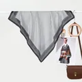 Detailansicht eines klassischen schwarz-weißen Seidenschals mit Punkten am Kleiderbügel - Schwarz Weiß