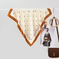 Detail van de zijden vierkante sjaal met gele ruit en zwarte stippen op ivoor - Stippen