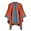 Detail of burnt orange knit poncho with light blue bohemian geometric patterns - Orange