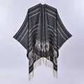 Detailed close-up of double-sided fringe poncho featuring ethnic geometric patterns and stripes - Black Coffee Jacquard
