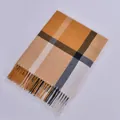 Detail of ginger plaid scarf showing soft cashmere texture and tassel fringe edge - Yellow