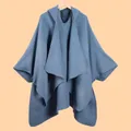 Detailed close-up of gray-blue knit poncho showing refined edge stitching on wooden hanger - Solid Hooded Blue Gray