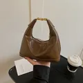 Sac à main hobo marron brillant chic avec boucle dorée élégante et forme demi-lune - Marron