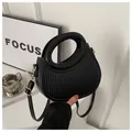 Detail of black semi-circle bag with vertical embossed texture and golden hardware - Black