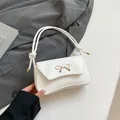 Borsa baguette bianca con chiusura a fiocco dorato e manico a corda annodata - Bianco