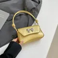 Borsa sottobraccio minimalista giallo pallido in ecopelle con fiocco argento e nodo - Oro