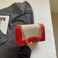 Sac bandoulière en toile rouge et kaki avec chaîne dorée au design moderne et chic - Bordeaux