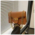Macro detail of brown crossbody bag featuring floral relief and golden M hardware - Brown