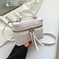 Chique witte geweven box-handtas met zilveren rits en slanke schouderband in hand - Wit