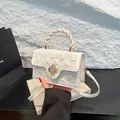 Sac à main blanc ivoire avec poignée torsadée, texture plissée et fermoir fleur dorée - Blanc