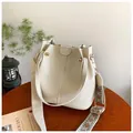 Crèmekleurige bucket bag van kiezelleder met een brede geweven vintage schouderband - Wit