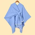 Detailed close-up of light blue knit poncho with fringe edges on wooden hanger - White Beard With Stripes And Light Blue Color / 130x150cm