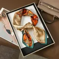 Écharpe élégante en soie à motif floral orange et vert présentée sur un plateau doré chic - 70x70cm / Orange Feuille Étoile