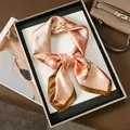 Elegant floral silk scarf in pink and gold tones displayed on a premium white tray - Scarf Style / Pink Plum Branch