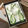 Detail of floral silk scarf in light green and cream neatly folded in a gift box - 70x70cm / Fresh Green Camellia