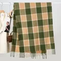 Detail of dark green and khaki plaid cashmere scarf with soft tassels on a white hanger - One Size / Yellow & Green