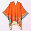Close-up of orange knitted shawl featuring blue ethnic patterns and cream fringe details - Pullover Poncho Origin Orange