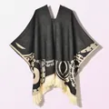 Close-up of ethnic geometric patterns and fine fringe detail on a warm knitted poncho - Pullover Poncho Origin Black