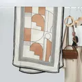 Détail d'une écharpe géométrique color-block avec imprimés sur un cintre minimaliste - Style à Bordure Rayée